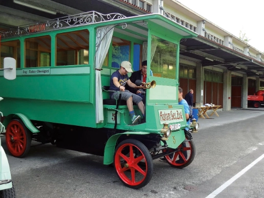Vor dem Fuhrpark, grünes Fahrzeug, Kind sitzt  in Fahrzeug