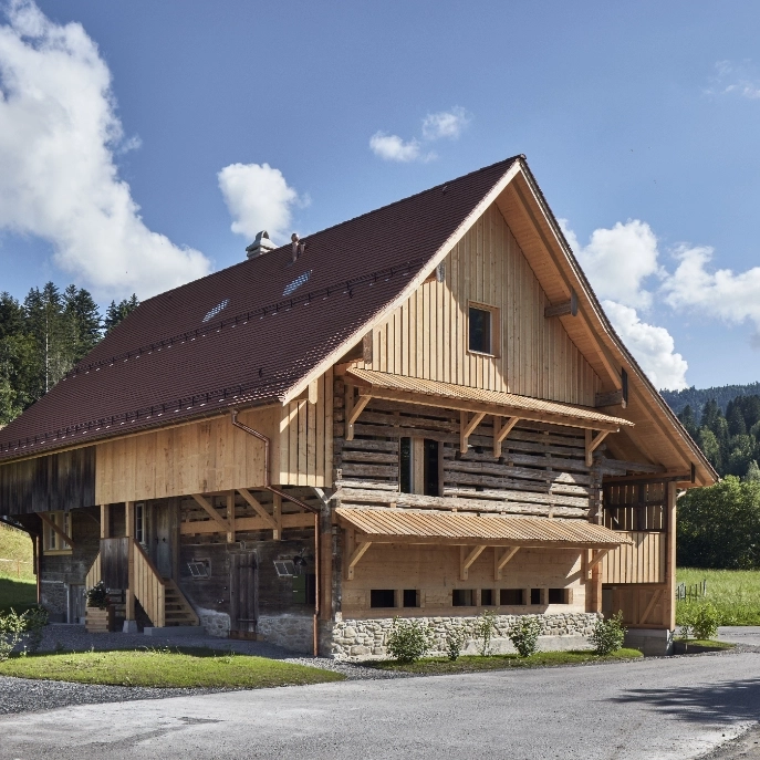 Ansicht der renovierten Fassade mit hellem Holz und der Strasse im Vordergrund