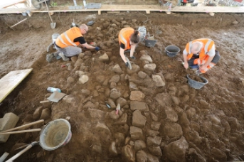 Cham, Äbnetwald. Grabungsmitarbeitende legen einen Abschnitt der über 20 m langen Ostmauer frei. Amt für Denkmalpflege und Archäologie Zug (David Jecker)