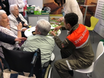 Bewohnerinnen des Alterszentrum Chlösterli sitzen mit einem Zivilschützer am Tisch